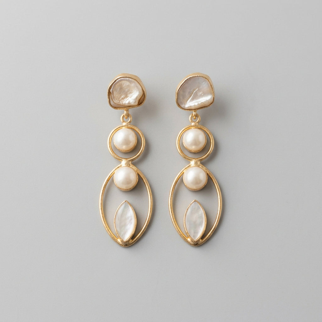 A pair of gold drop earrings with white faux pearls and iridescent shell-like beads, made in brass