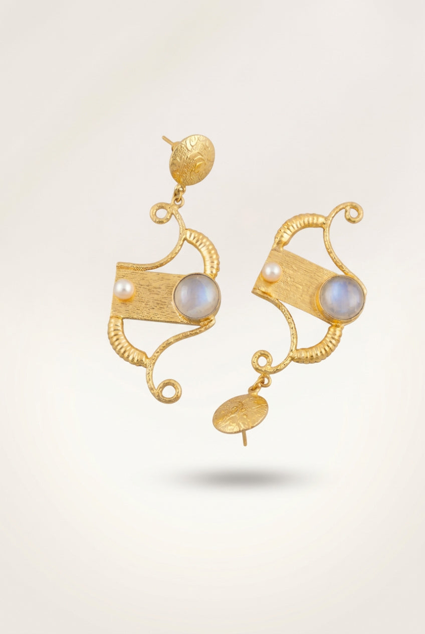 A pair of gold-toned statement earrings with textured scrollwork, a central rectangular gold plaque and a round gray stone