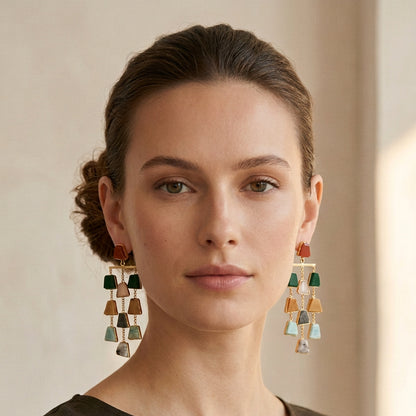 A pair of gold-tone dangle earrings with multiple small geometric stone charms in green.