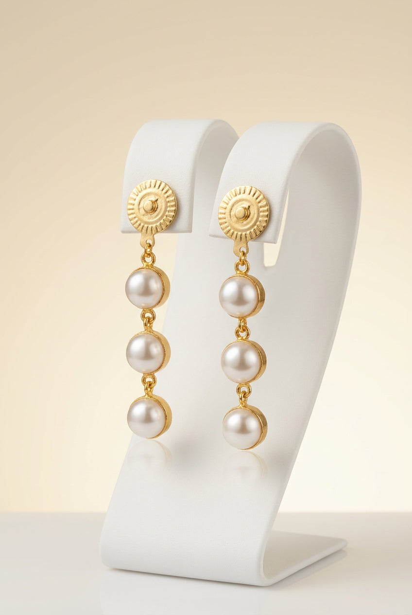 A pair of gold-plated dangle earrings with three white faux pearls, for festivals